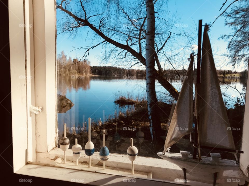A view to the lake through a window with a decoration 