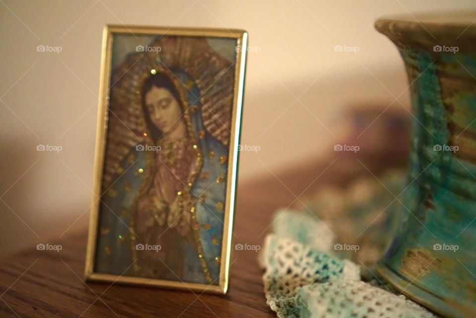 Guadalupe. A picture of Our Lady of Guadalupe sits beside an ornate piece of Mexican pottery.