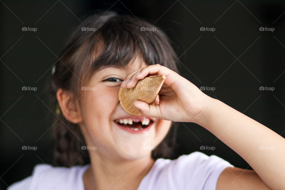 Cute little girl is playing with a waffle ice cream cone