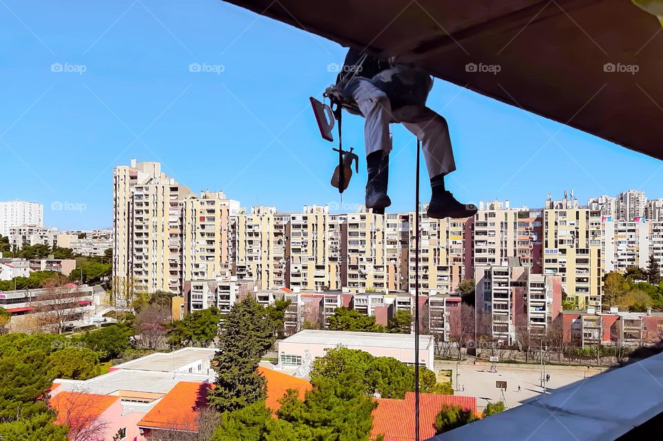 Provided with mountaineering equipment, the worker performs work on the facade of the building