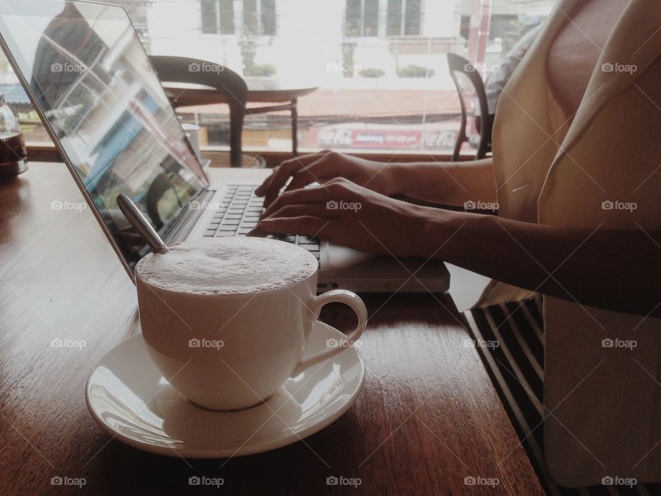 Woman working on a laptop with a cup of coffee