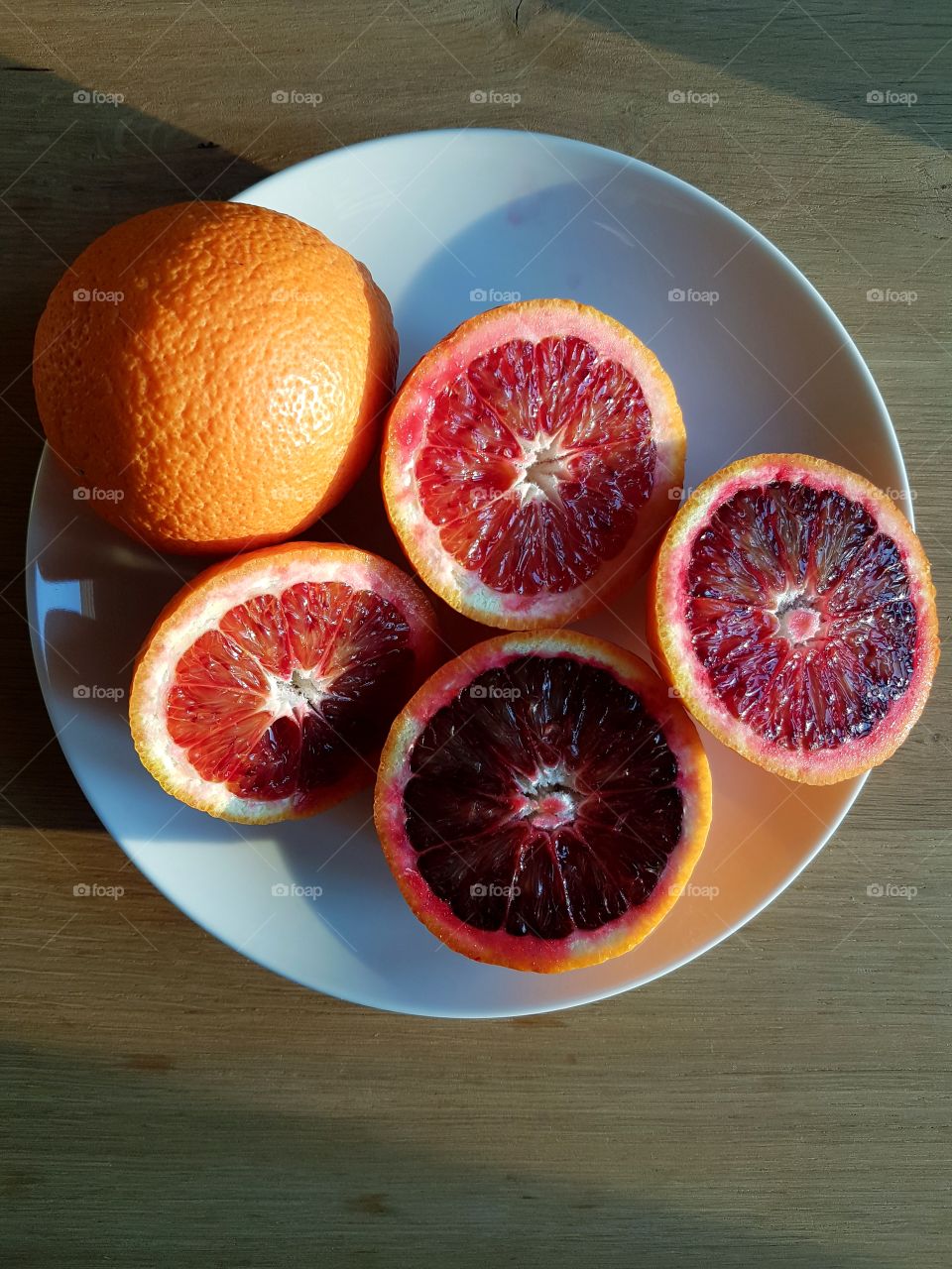 Blood oranges cut in half in a withe dish