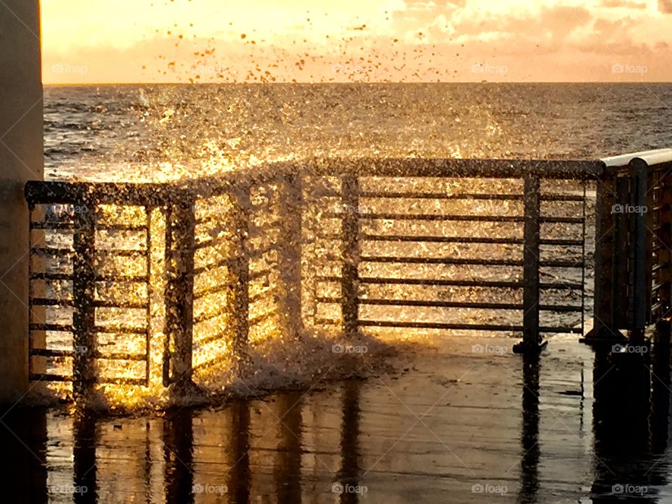 Sea of gold at Boynton beach inlet at Boynton beach FL as waves splash during sunrise 