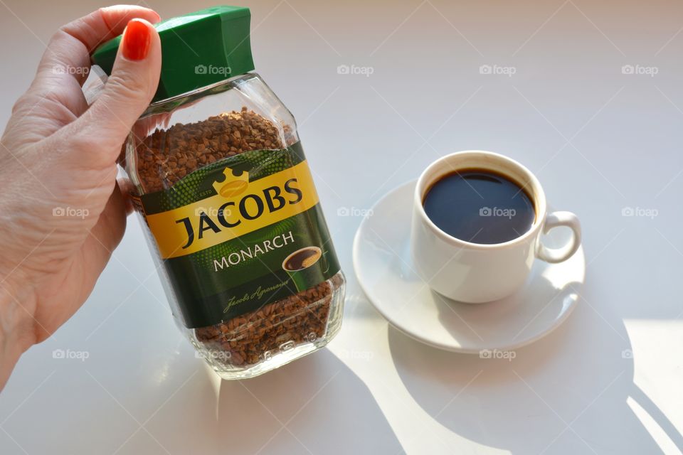 coffee Jacobs in the female hand and coffee mug on a white background, morning routine