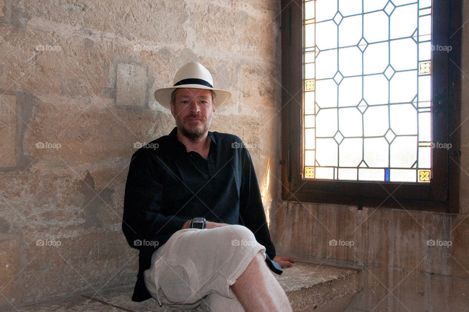 Man sits by window in Medieval Castle