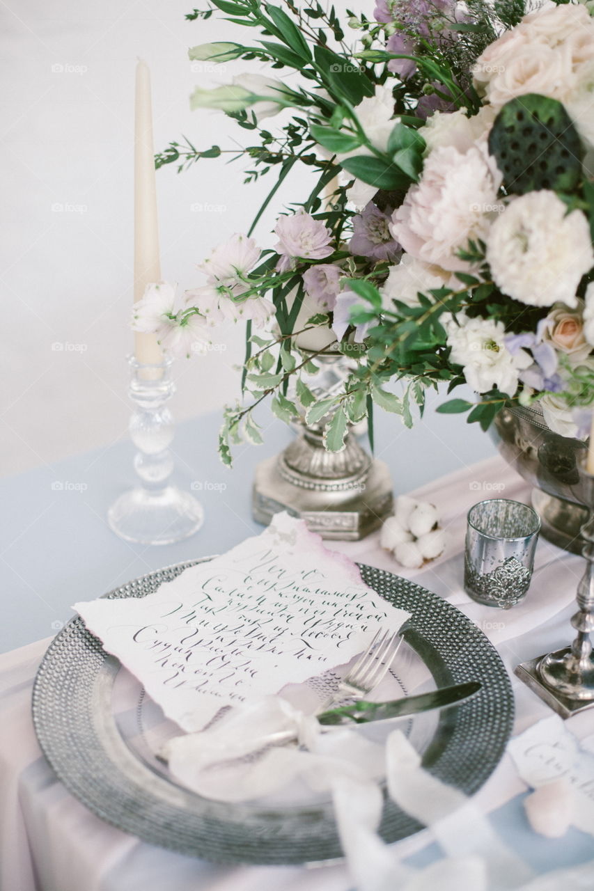 Silver candlestick and other elements of festive table wedding centerpieces decorations.