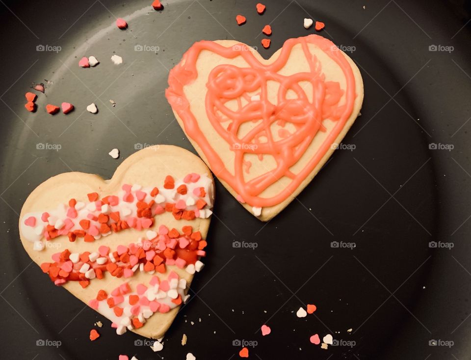 Plate of valentine heart shaped cookies displayed on a black plate 