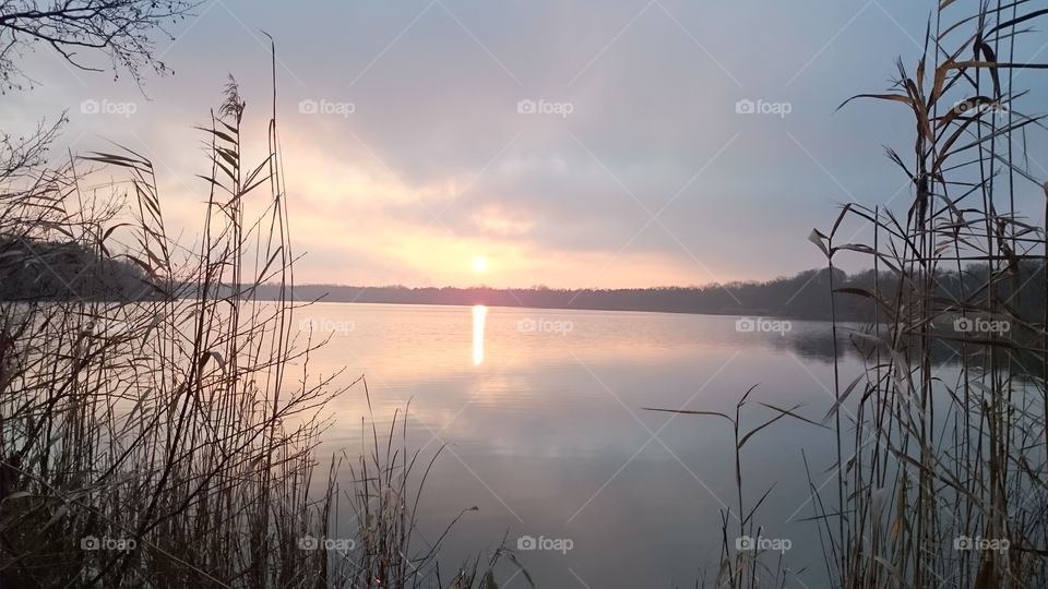 Sunset with reflecting sun and sky in the lake