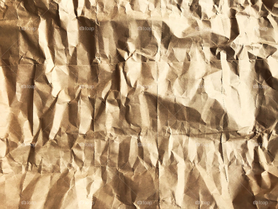 full frame of dramatic brown crumpled paper looks like rock