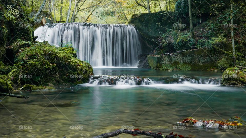 Beautiful long exposure photo of a cascade on a stream in lush green forest