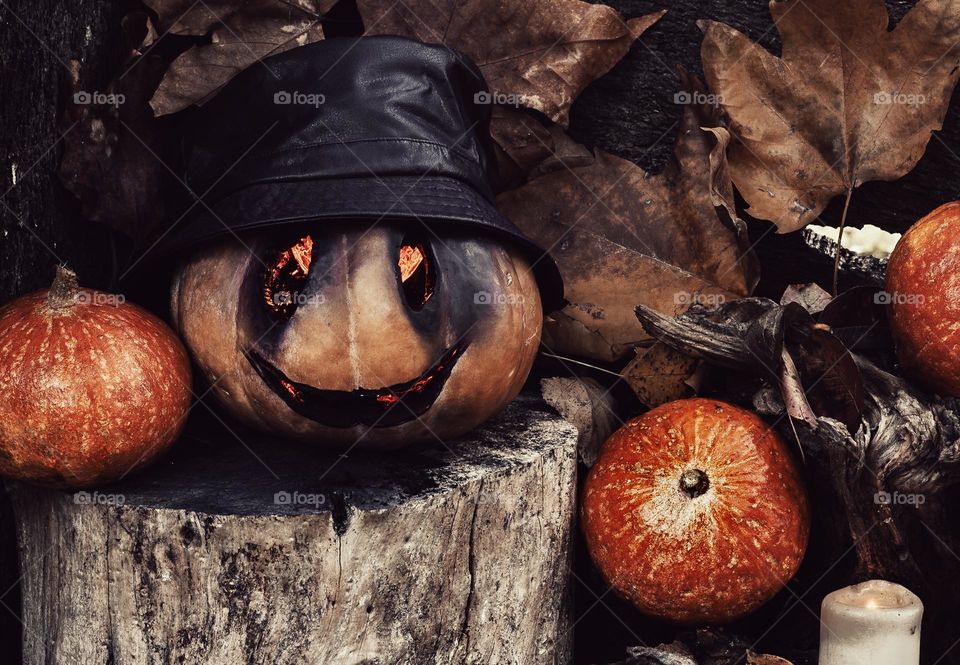 Creepy pumpkin face, with other pumpkins and leaves