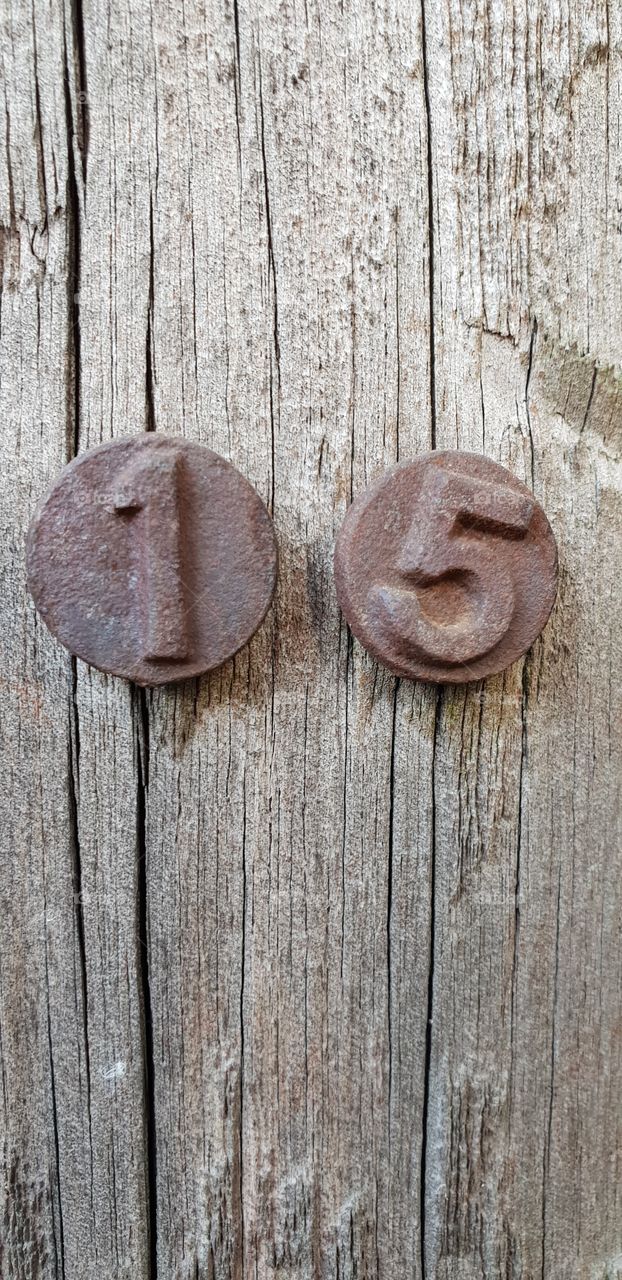 iron number sign nailed into oak post