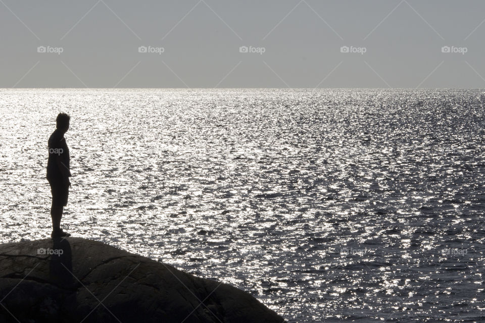 Man standing on the rocks by the sea