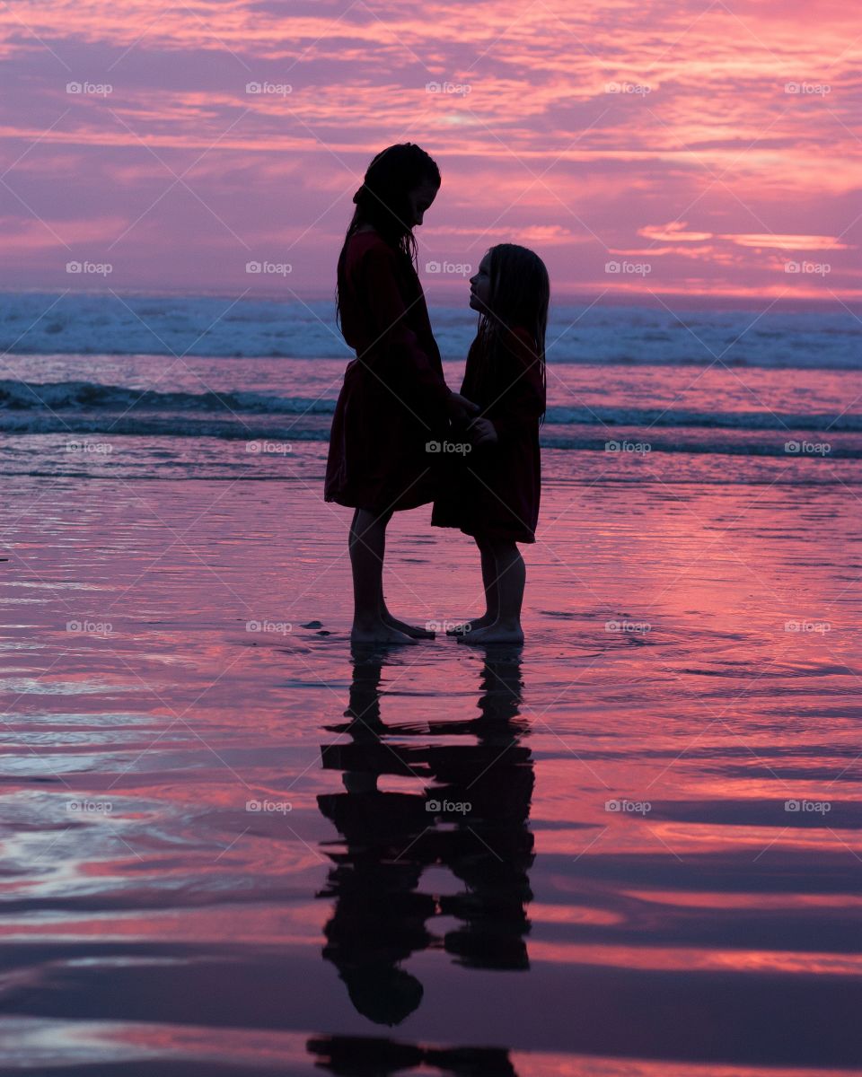 Sunset sisters. Sister silhouette on a pink sunset 