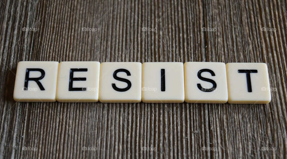 Letters spelling resist on wood background