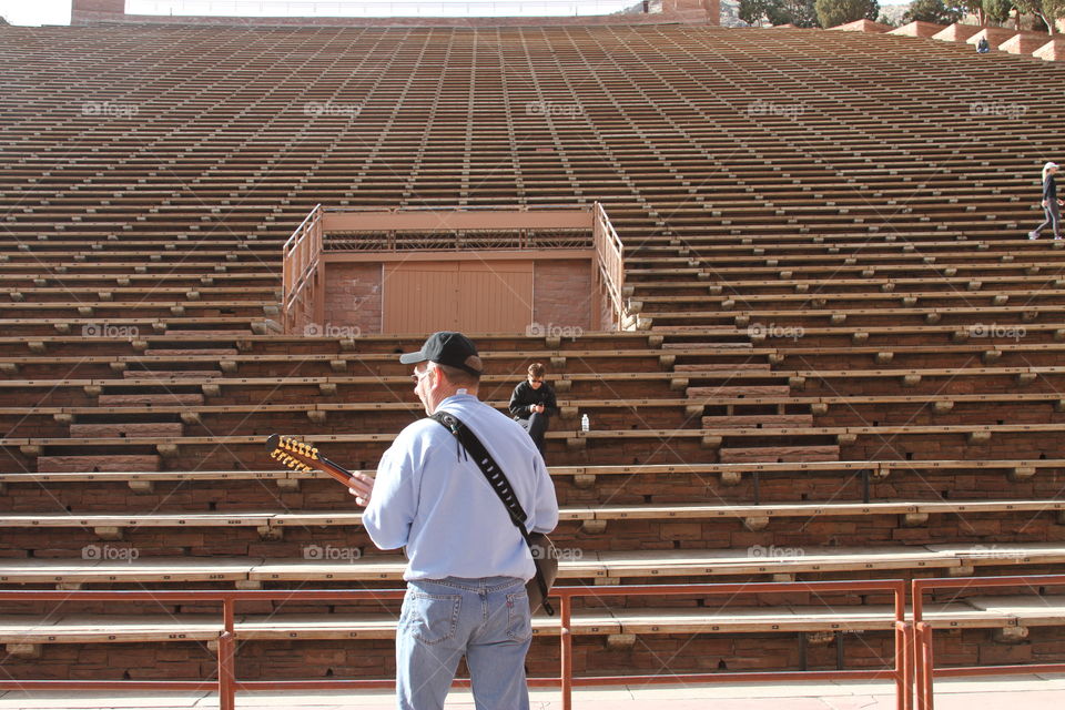 Man playing guitar in empty arena
