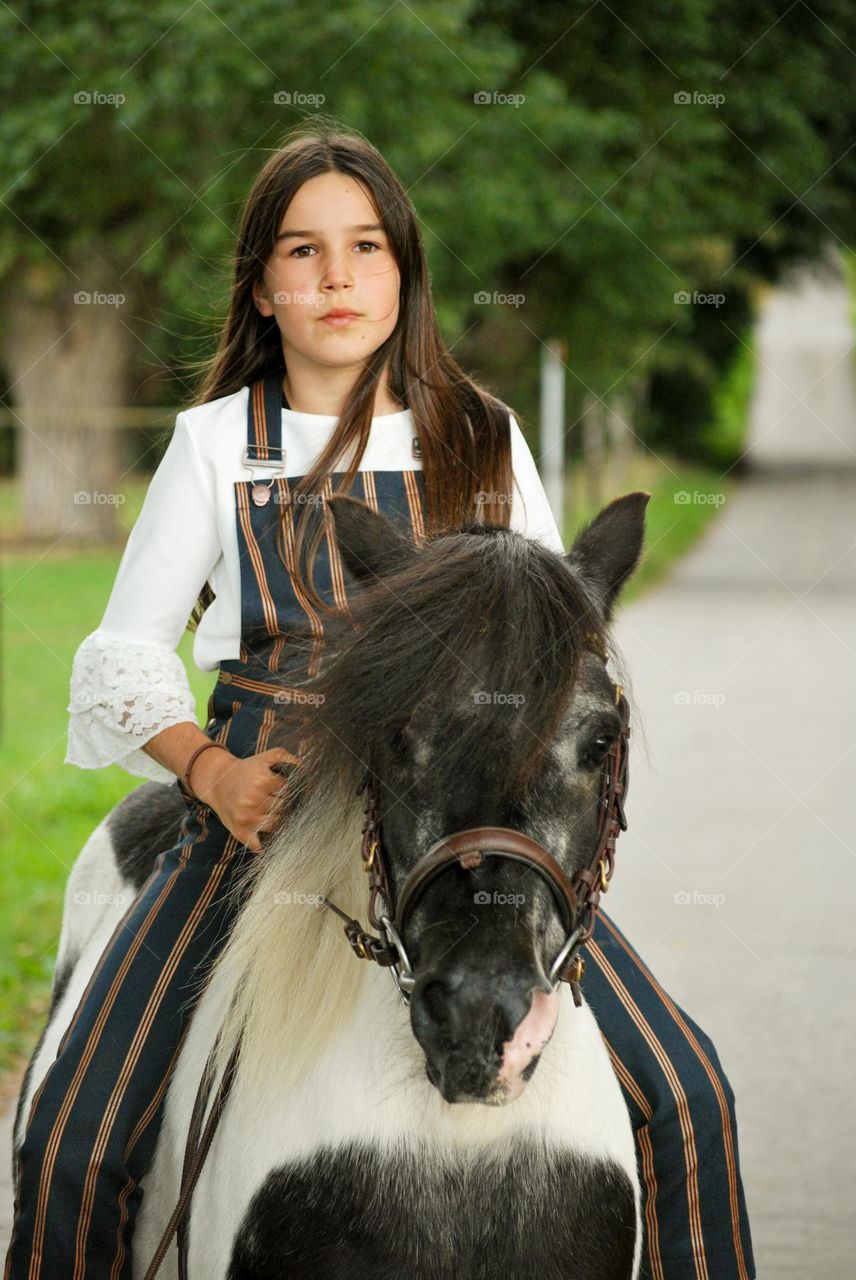 Teenage girl riding her horse in nature in the countryside