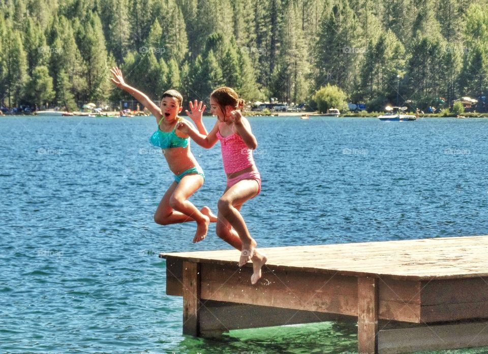 Girls Jumping Into A Summer Lake