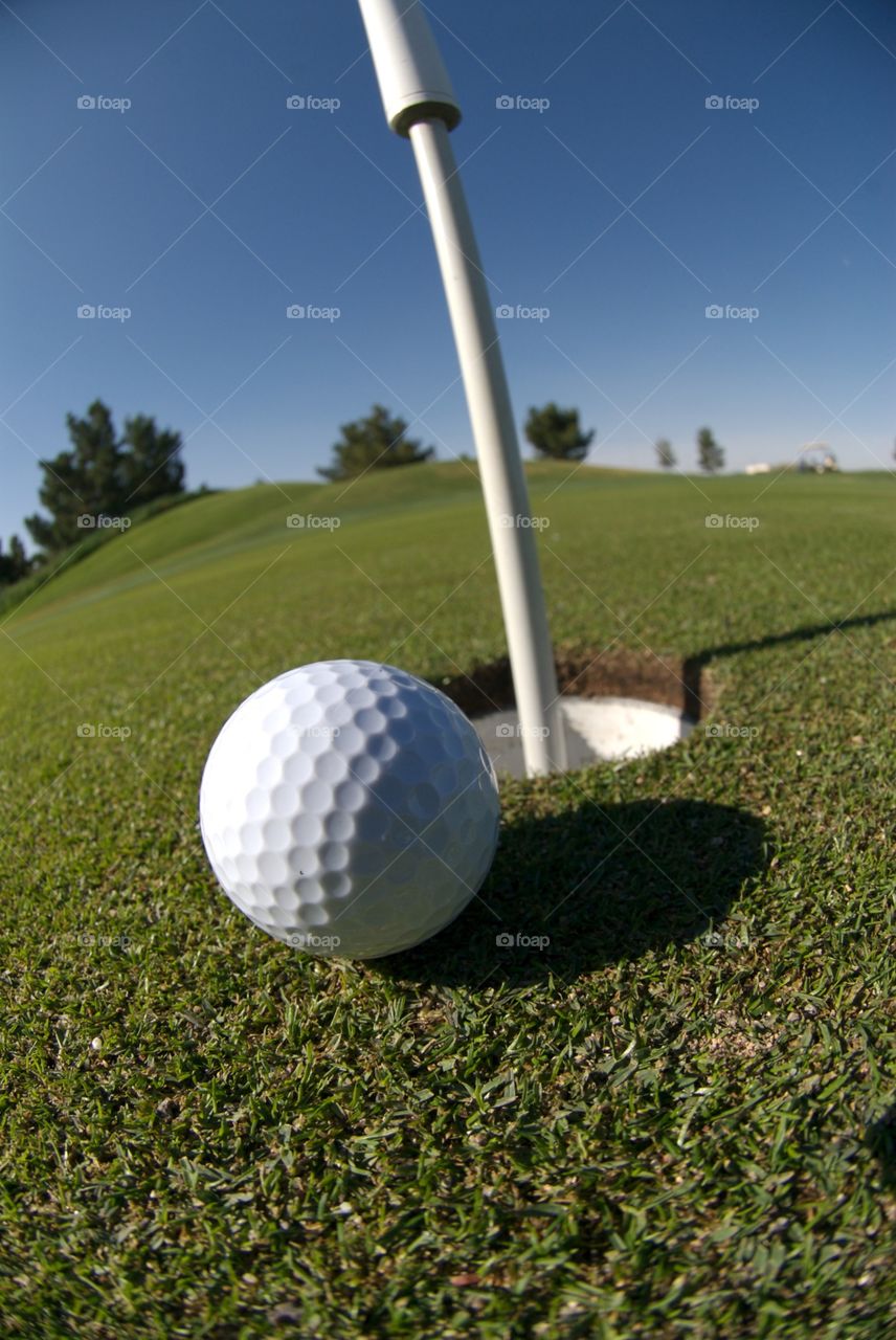 Golf ball about to go in cup