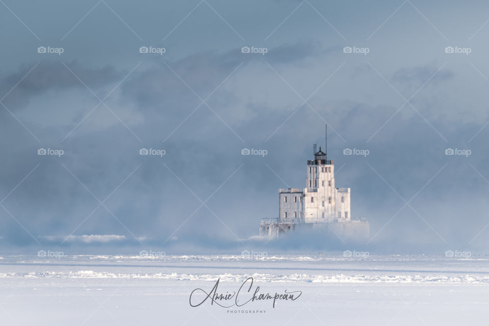 White lighthouse on Lake Michigan in Milwaukee, WI during winter