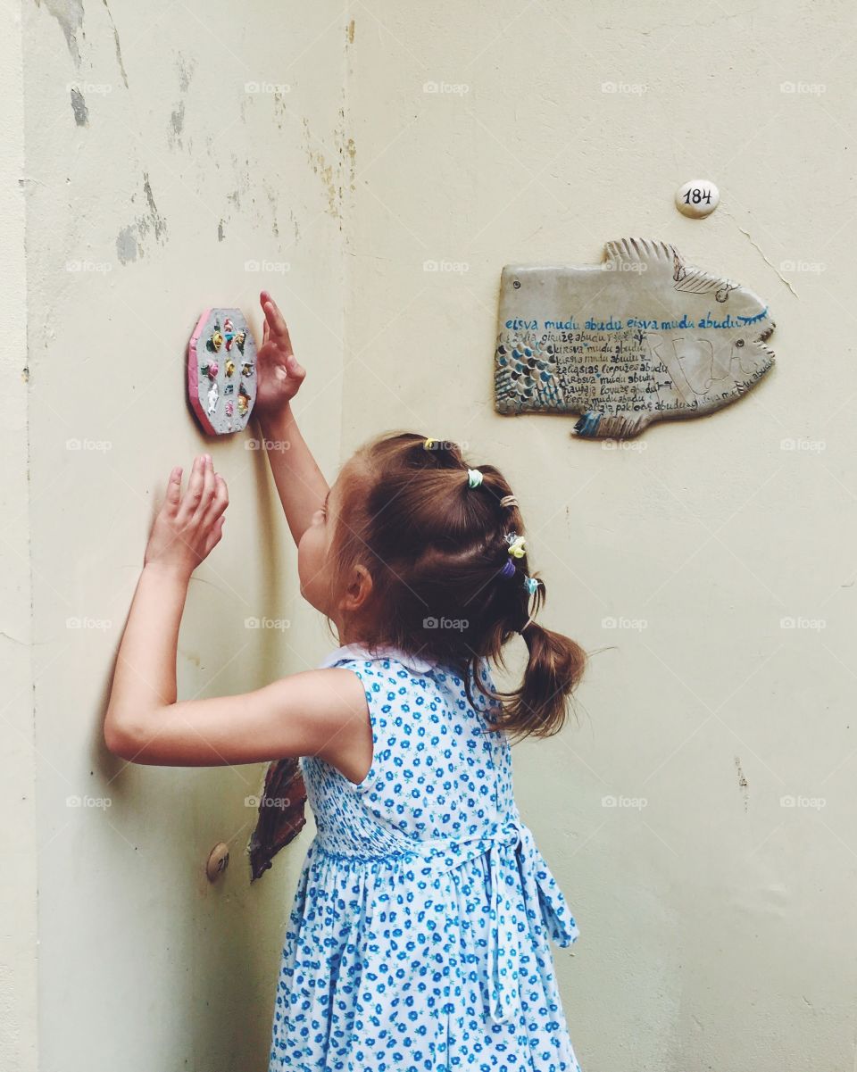 Girl looking on the ceramics in the wall 