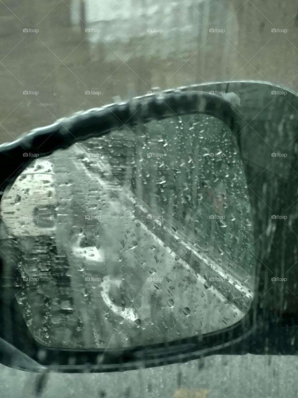 Rain on window with mirror in background