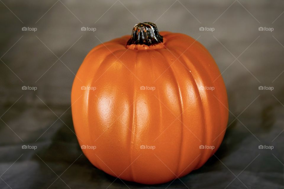 Plastic pumpkin in studio setting ready to be used in Halloween decorating