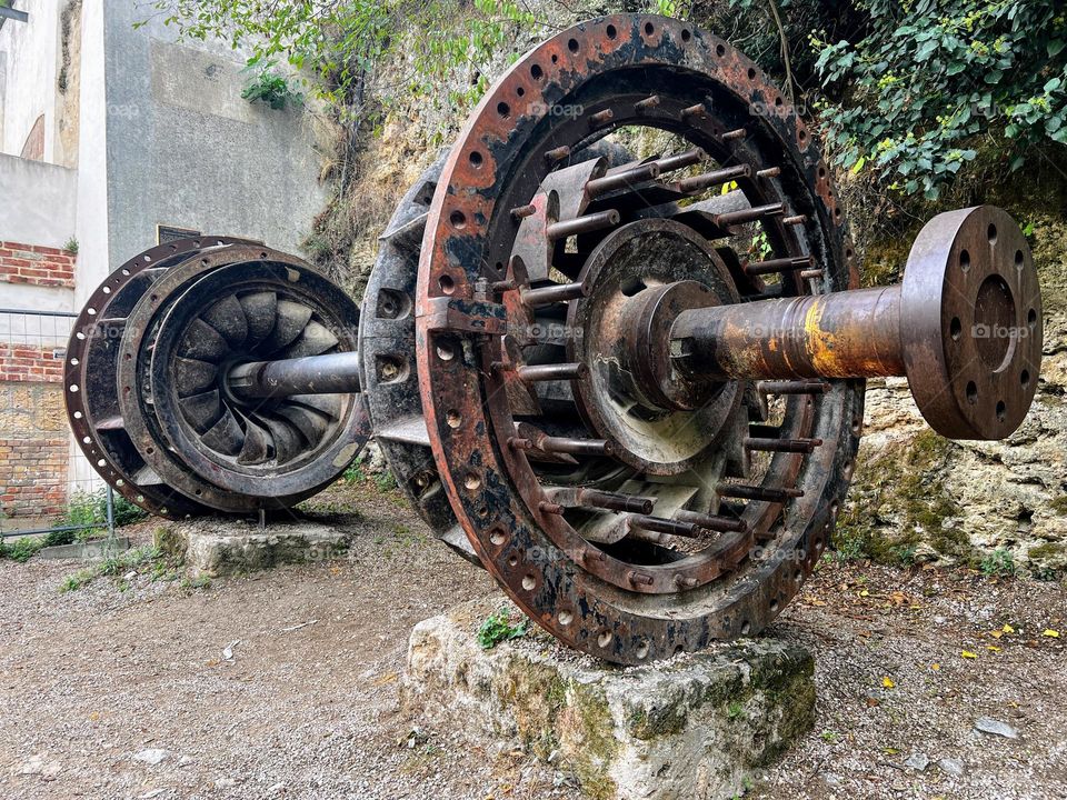 Side angle view to the big old iron rusty axis with gears