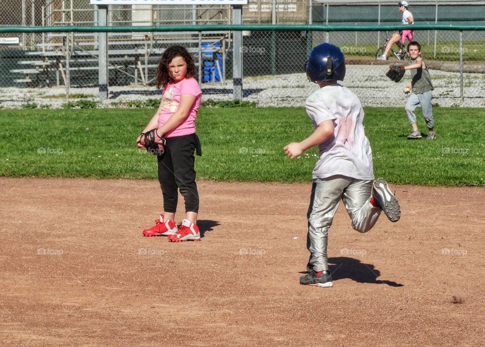 Young Baseball Player Stealing Third Base. Boys And Girls Playing Baseball
