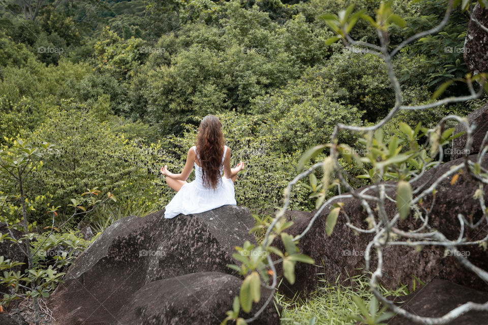 Girl in white dress doing yoga in nature