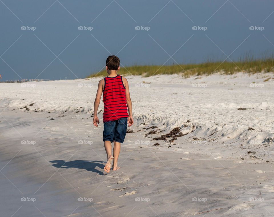 A boy walking on the beach