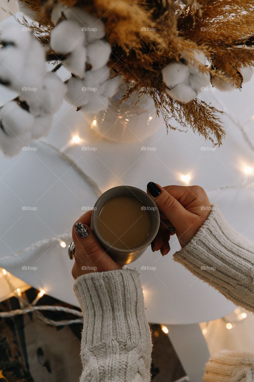 Cup of coffee with milk in female hands