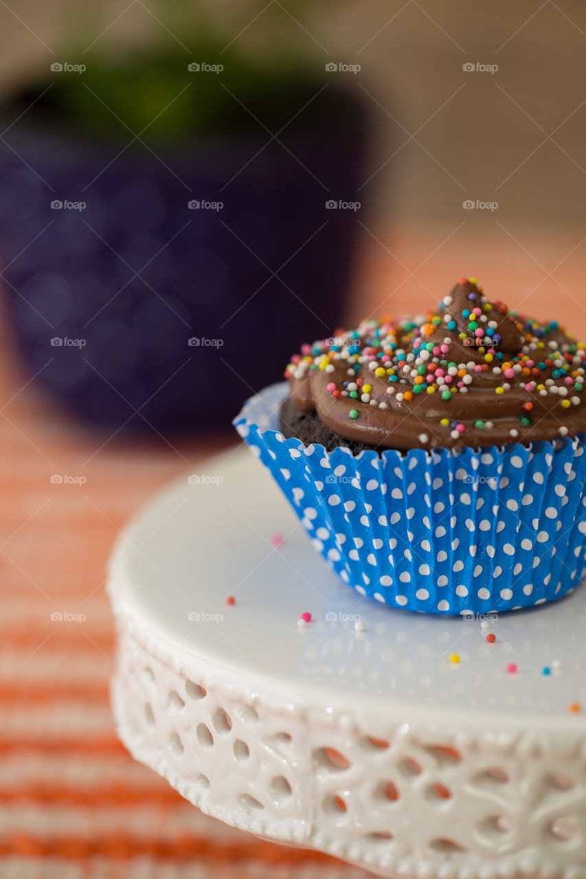 cupcake with chocolate ganache and colored sprinkles