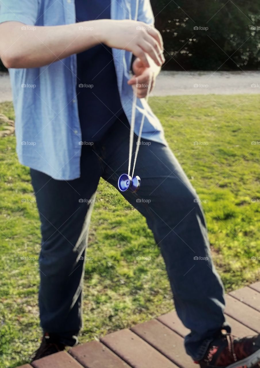 A man yoyoing in a grass filled yard spring into summer