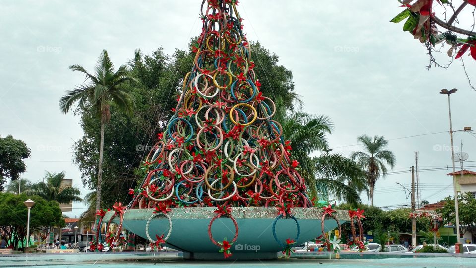 Reciclagem. Escultura de arvore de natal, sobre fonte de praça. Com muitos pneus velhos de bicicletas, pintados com varias cores.