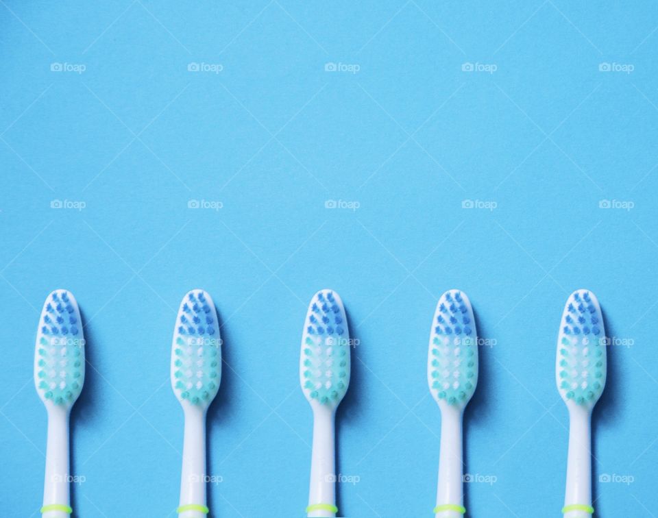 Flat lay of blue toothbrushes on blue background