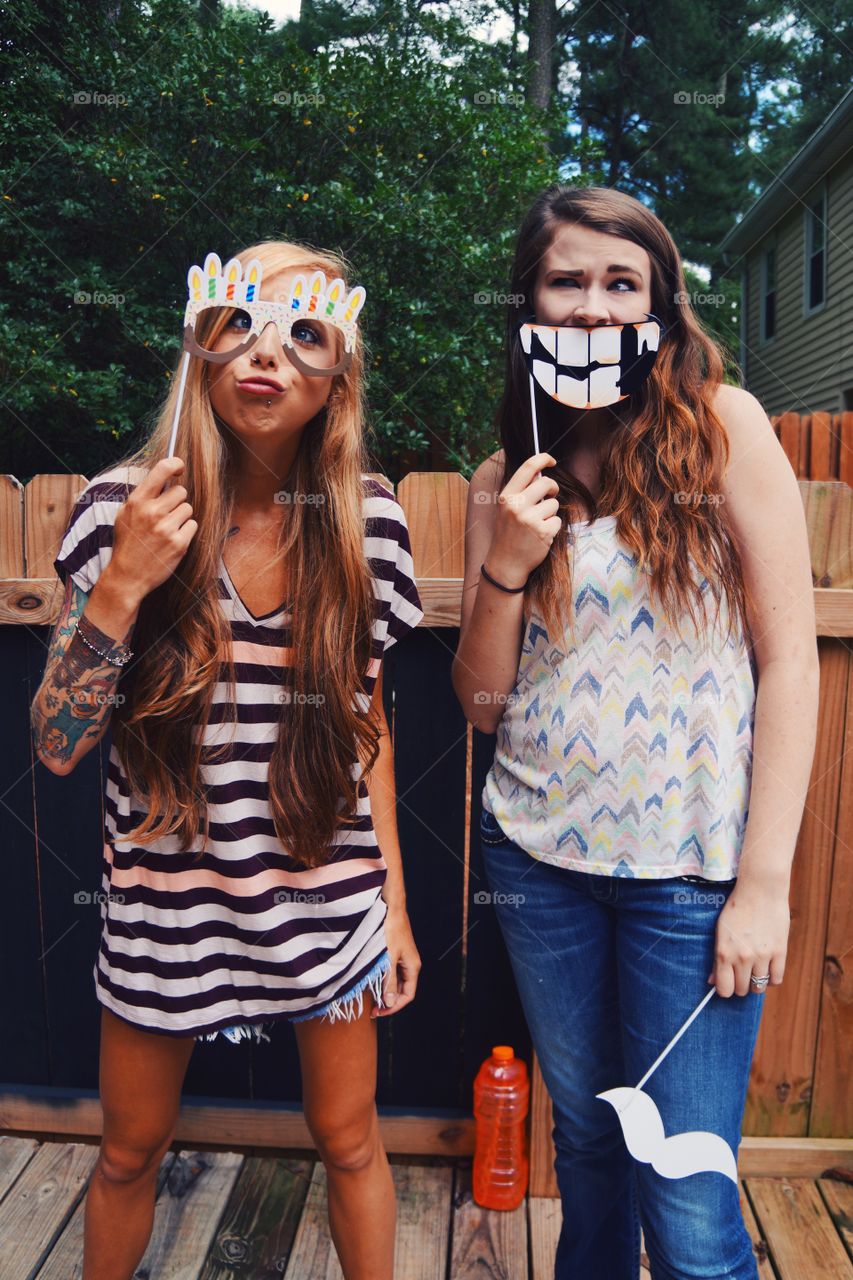 Close-up of teenage girl holding funny mask in hand