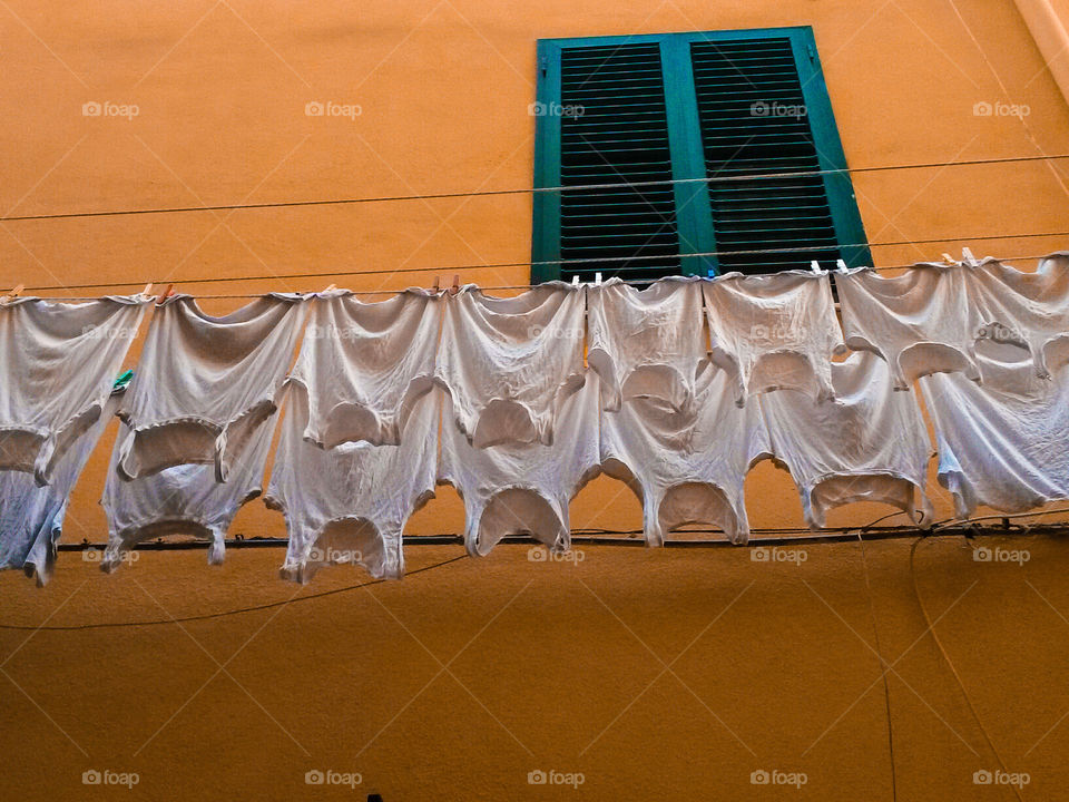 multiple white undershirt drying outdoors