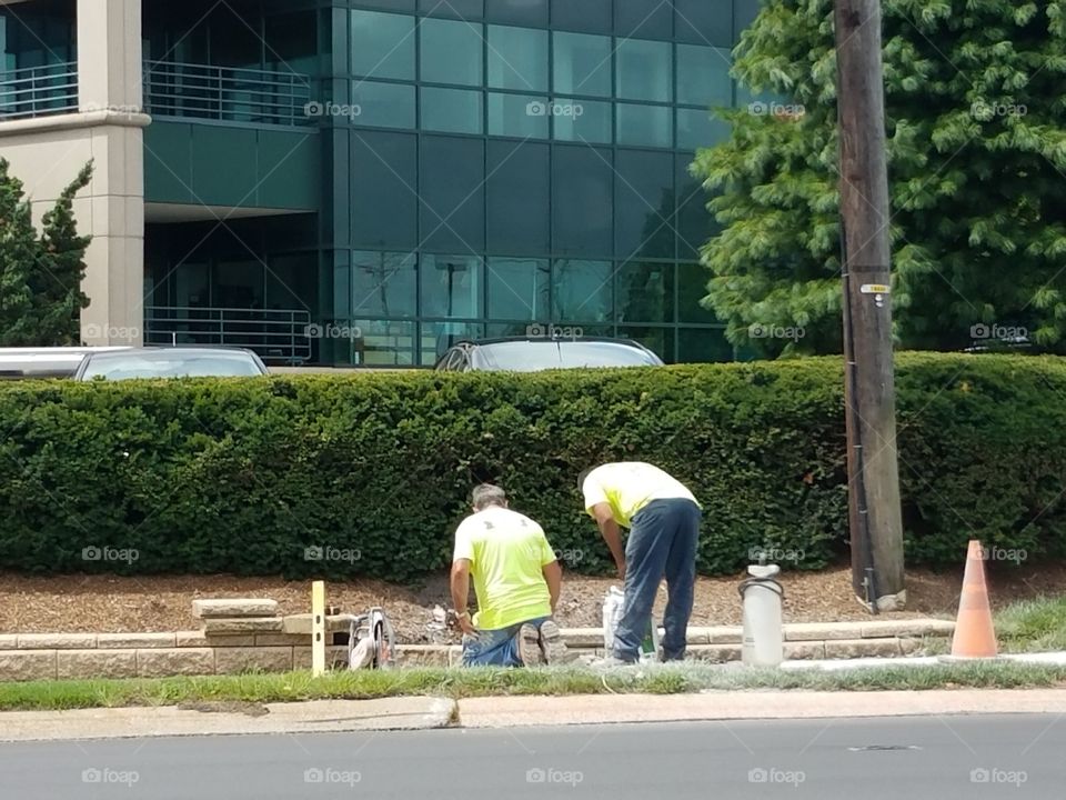 Paving crew works on a sidewalk.