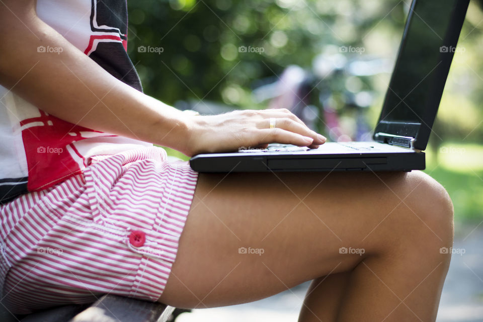 woman using laptop. woman using laptop in park sitting on bench