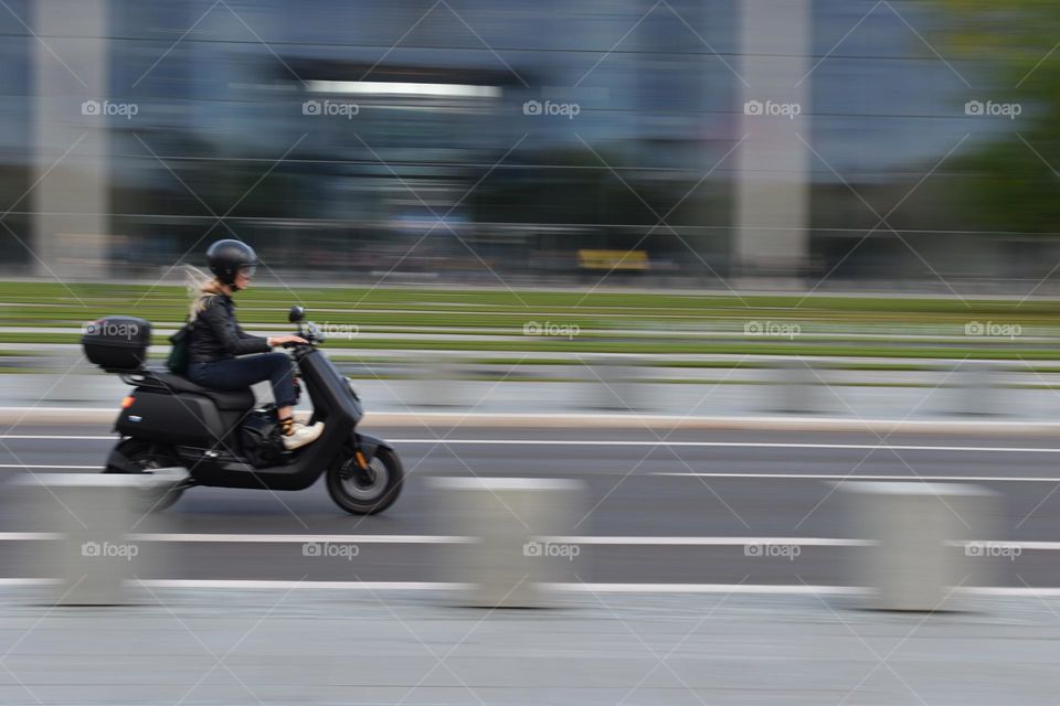 A biker on the street, picture taken with long exposure for the background.