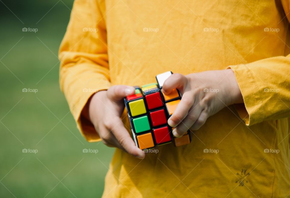 Boy trying to figure out the solution to the Rubik’s cube