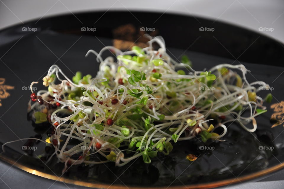 fresh green sprouts on black plate healthy diet closeup