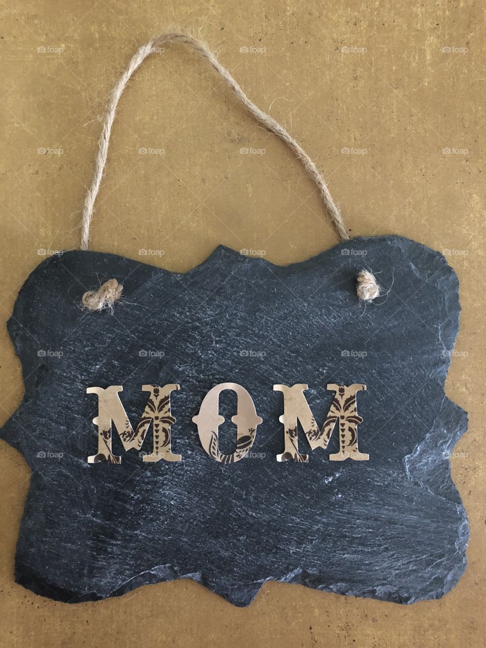 Mom spelled with decorative letters on light brown background 