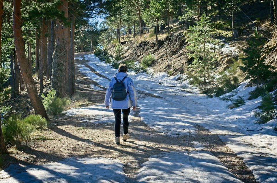 A woman hikes on the snowy path 