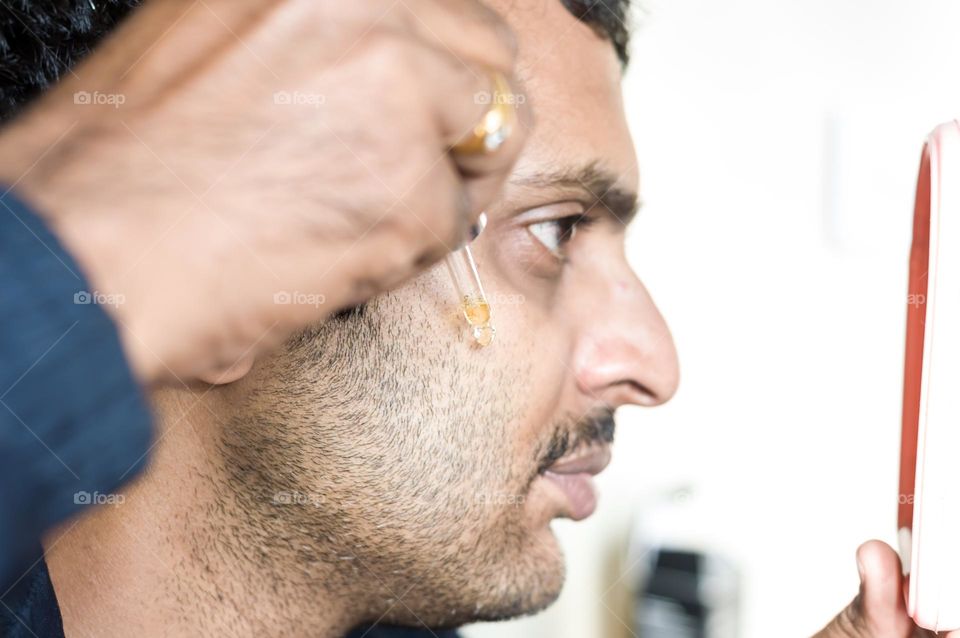 Man applying beard oil.