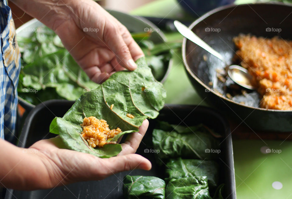 Home cooking. A woman wraps rice in edible leaves, prepares a traditional dish for the Balkans called sarmi