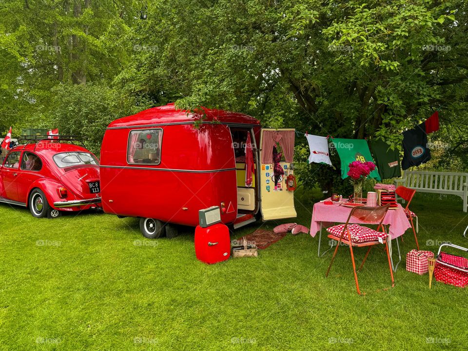 Red car with caravan on picnic