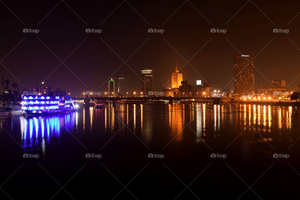 Cairo by night over the nile river with building reflections