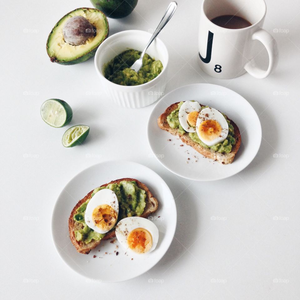 Healthy breakfast with avocado toasts and boiled eggs.
